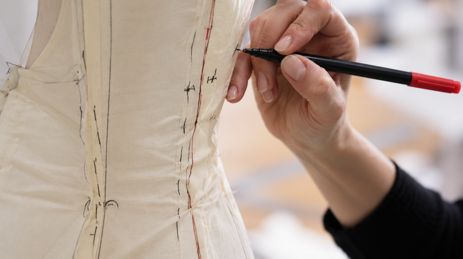 Marking the toile on the mannequin to refine the shape